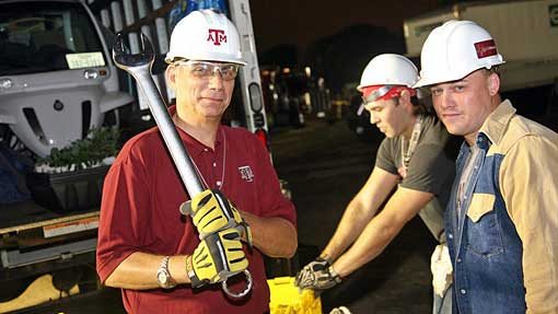 Leslie Feigenbaum helps Aggie Solar-D students unload one of three trucks. with students.